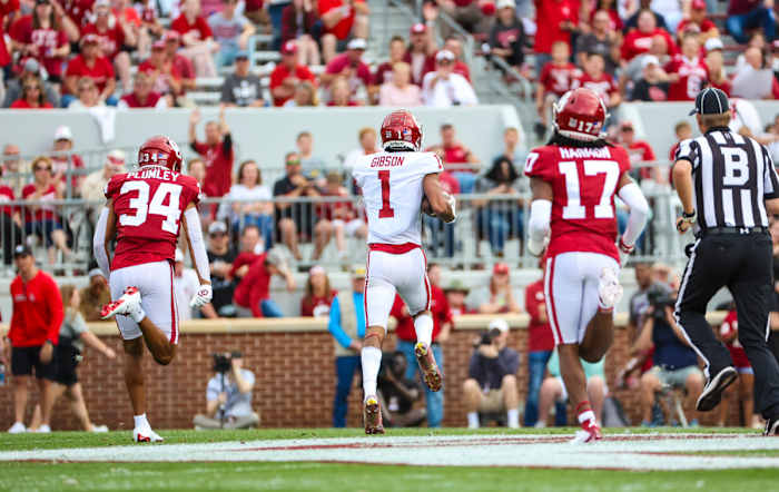 Oklahoma Sooners wide receiver Jayden Gibson scores a touchdown while two of his teammates chase after him in the annual spring game